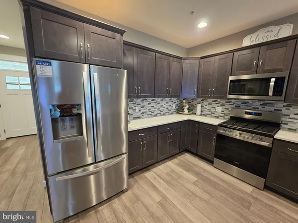 a kitchen with stainless steel appliances granite countertop a refrigerator and a stove top oven