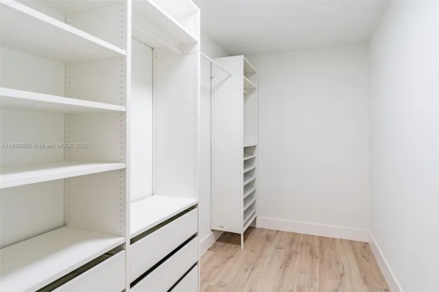 a view of walk in closet with empty racks