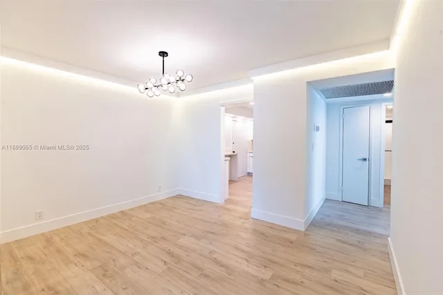 a view of a chandelier in big room and a bathroom