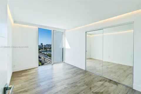 an empty room with wooden floor and closet
