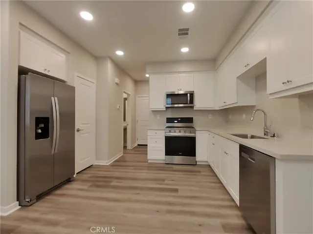 a kitchen with kitchen island a sink stainless steel appliances and cabinets