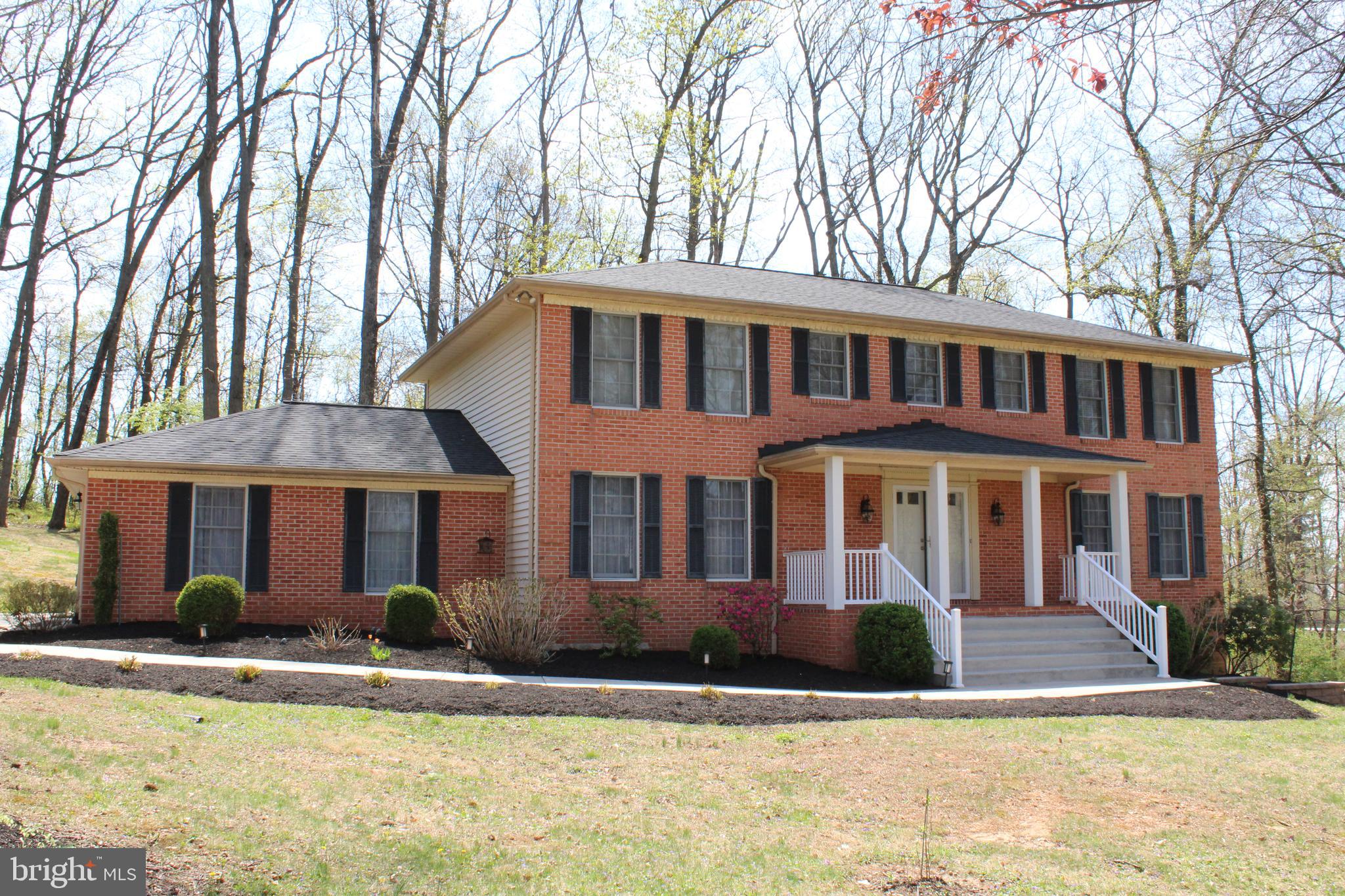 4036 Roop Road New Windsor, MD 21776 - Photo 2 of 55 a front view of a house with yard and trees in the background