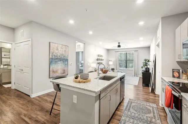 a kitchen that has a sink a stove and chairs