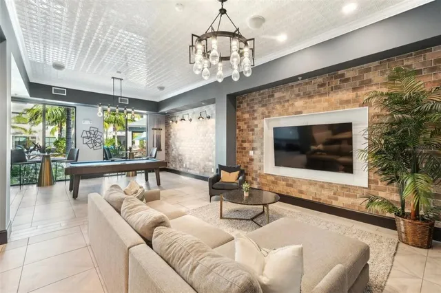 a living room with furniture a chandelier and a flat screen tv