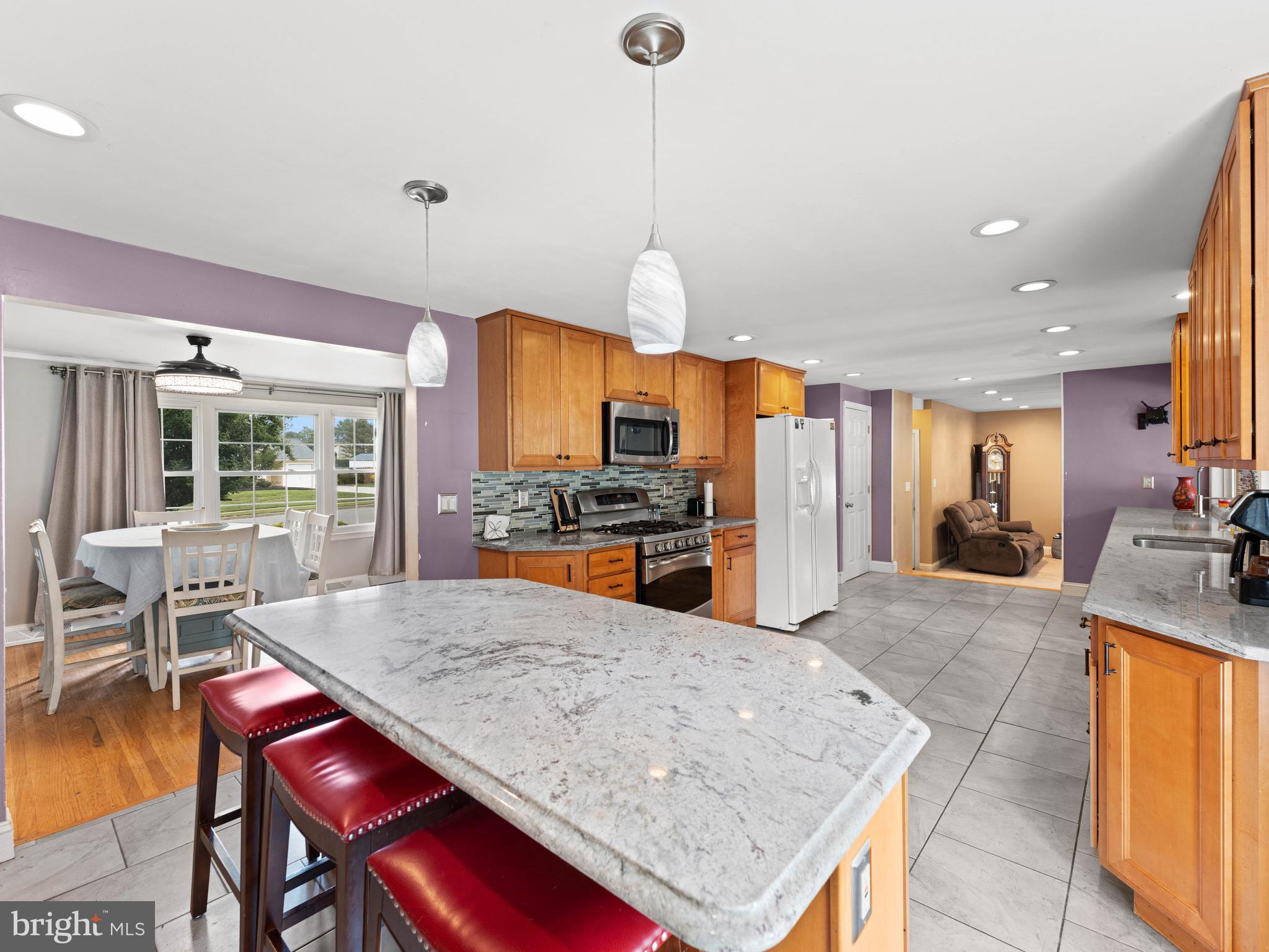 2505 Yellowstone Road Cinnaminson, NJ 08077 - Photo 25 of 40 a kitchen with stainless steel appliances granite countertop a stove top oven a sink a dining table and chairs with wooden floor