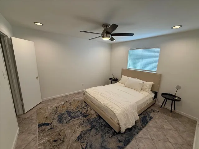 a bedroom with a bed and a ceiling fan