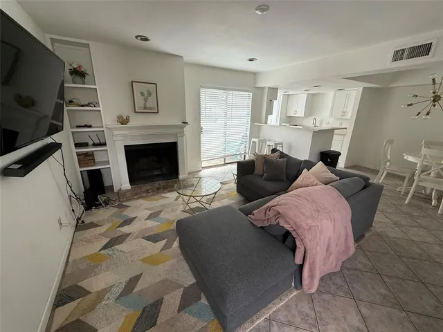 a bedroom with furniture a flat screen tv and a fireplace