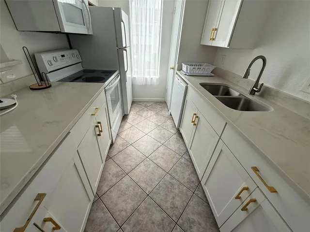 a kitchen with a sink a stove and cabinets