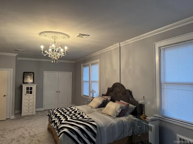 a bedroom with a bed and a chandelier