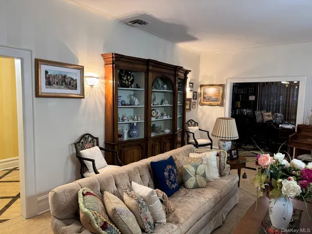 a living room with furniture a window and a potted plant