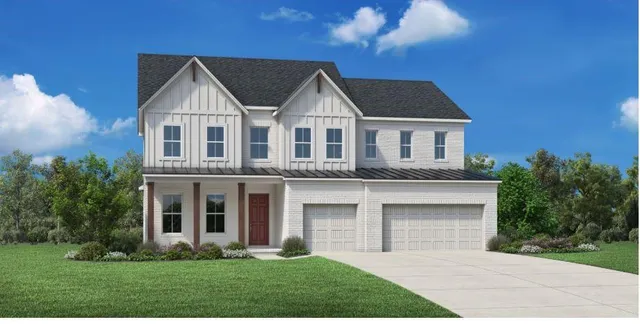 a front view of a house with a yard and trees