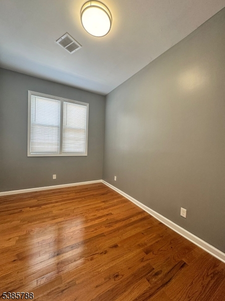 705 South 15th Street Newark, NJ 07103 - Photo 18 of 26 an empty room with wooden floor and windows