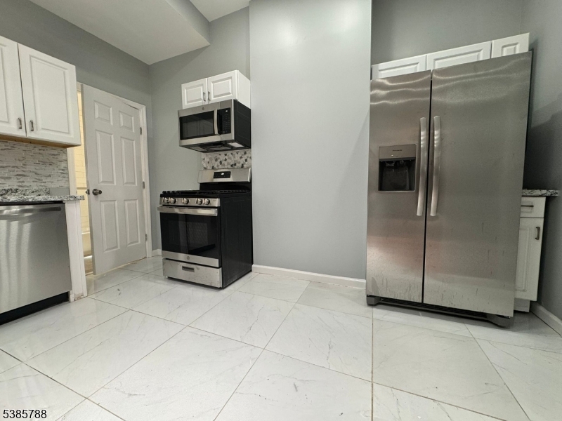 705 South 15th Street Newark, NJ 07103 - Photo 22 of 26 a kitchen with granite countertop a refrigerator and a stove