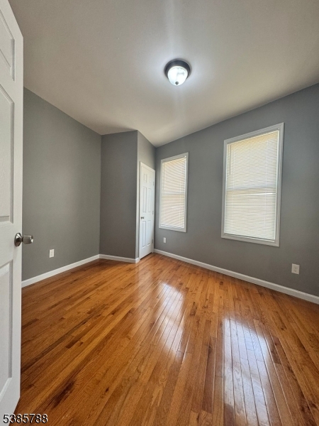 705 South 15th Street Newark, NJ 07103 - Photo 25 of 26 an empty room with wooden floor and windows