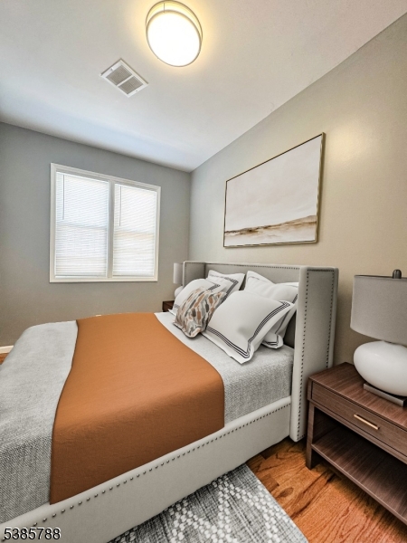 705 South 15th Street Newark, NJ 07103 - Photo 8 of 26 a bedroom with a bed and wooden floor