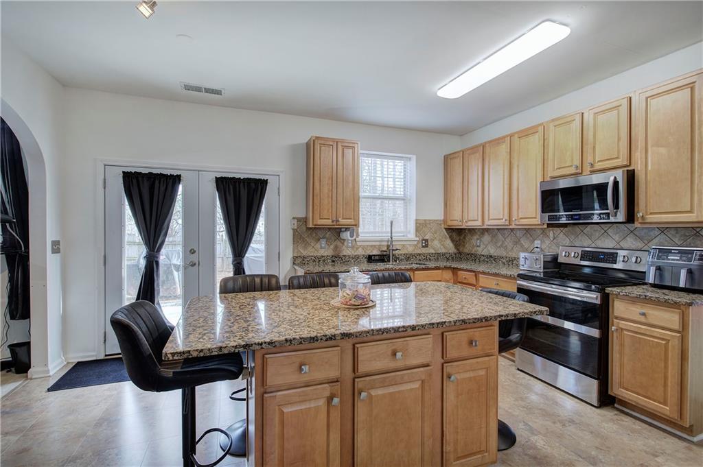 4508 Howell Farms Road Northwest Acworth, GA 30101 - Photo 11 of 42 a kitchen with granite countertop a sink dishwasher stove and microwave with wooden floor