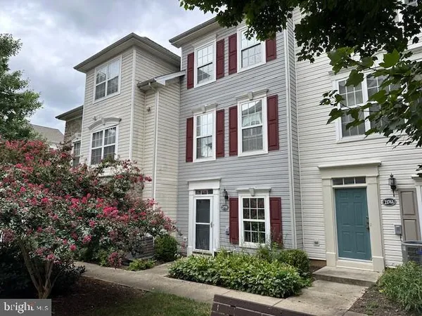 front view of a brick house with a yard