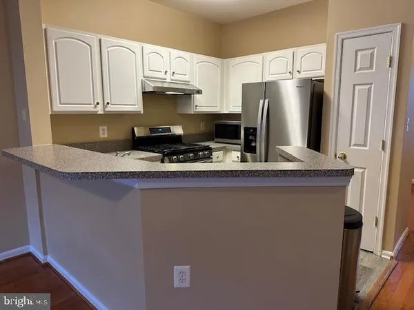 a kitchen with stainless steel appliances granite countertop a refrigerator a stove a sink and a granite counter tops