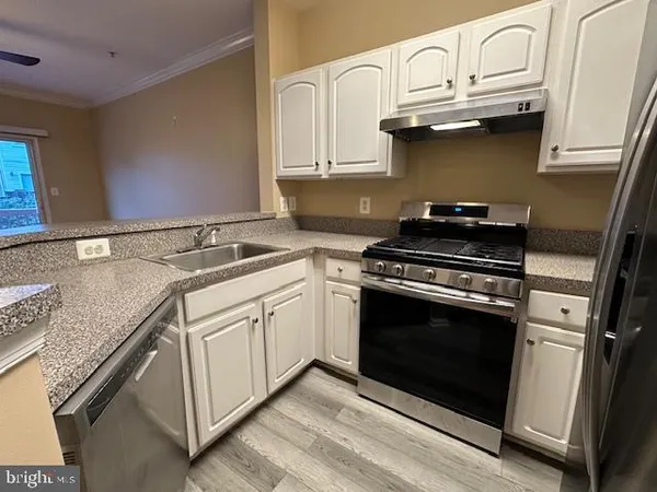a kitchen with granite countertop a stove and a sink