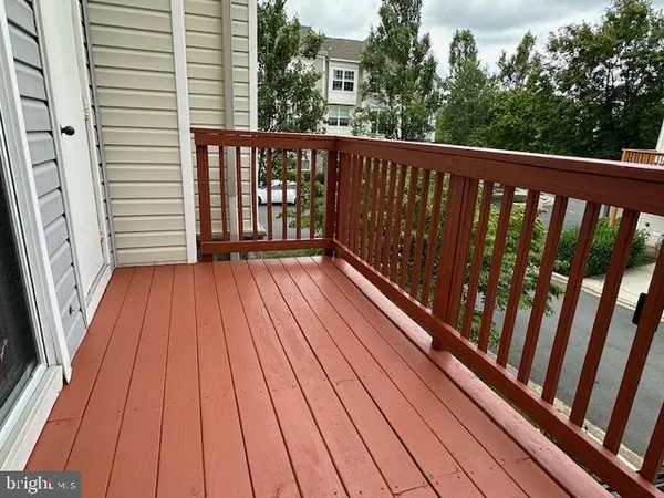 a balcony with wooden floor and trees in the back