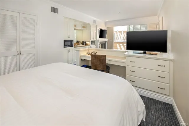 a bedroom with a flat screen tv and dresser