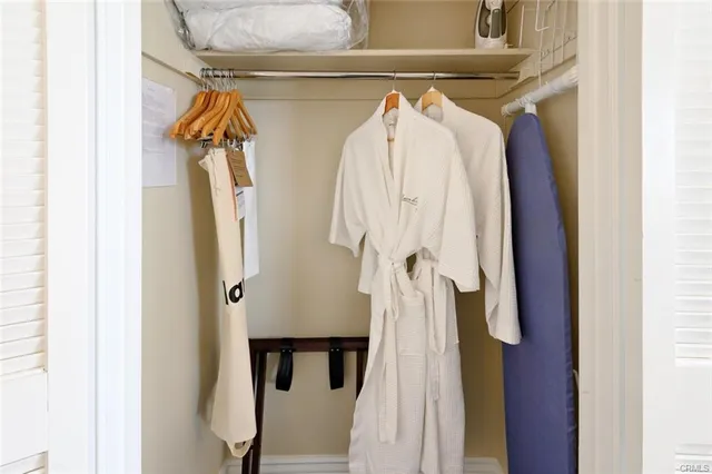 a view of walk in closet with clothes and shoes