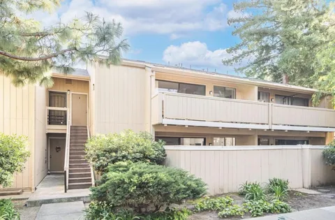 a front view of a house with plants and garden