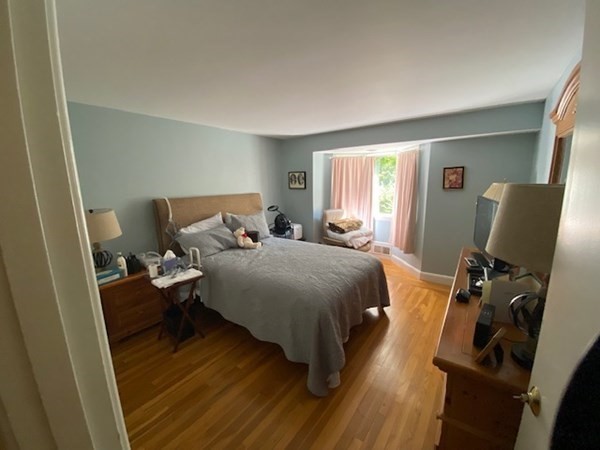 76 Woodledge Road Needham, MA 02492 - Photo 9 of 12 a bedroom with a bed and a flat tv screen on the dresser