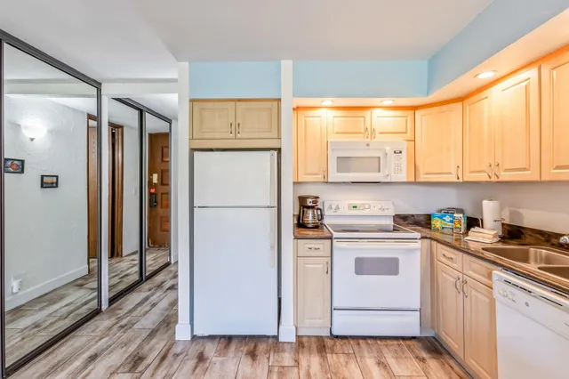 a kitchen with a refrigerator a stove top oven and white cabinets