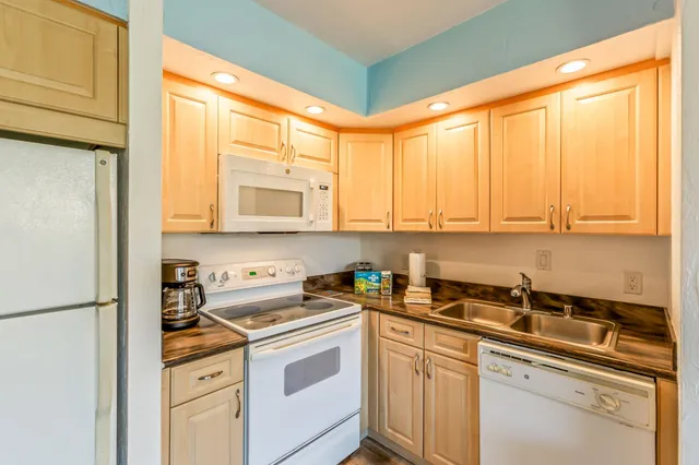 a kitchen with stainless steel appliances a sink cabinets and a window