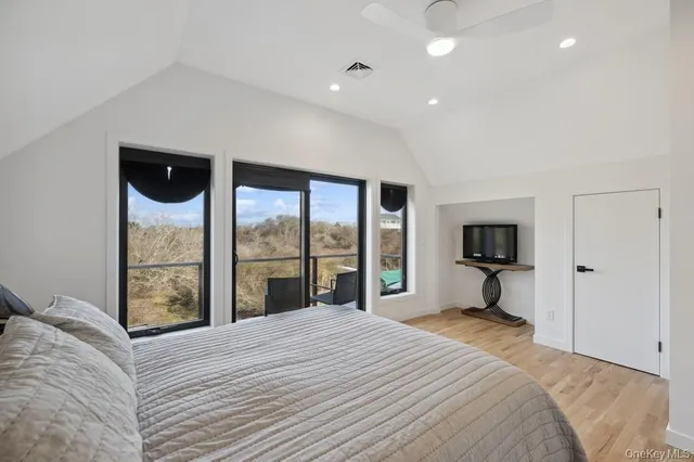 a bedroom with a bed and a large window with balcony view