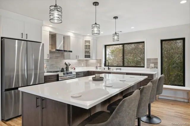 a kitchen with granite countertop a sink a center island stainless steel appliances and cabinets