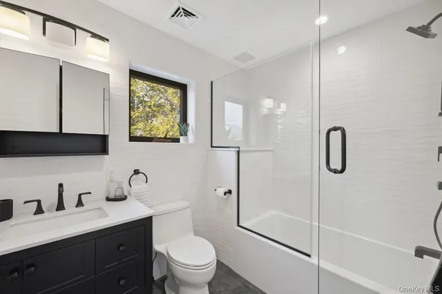a bathroom with a double vanity sink toilet and shower