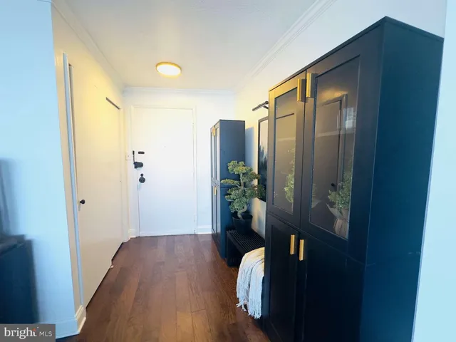 a view of hallway with livingroom and wooden floor