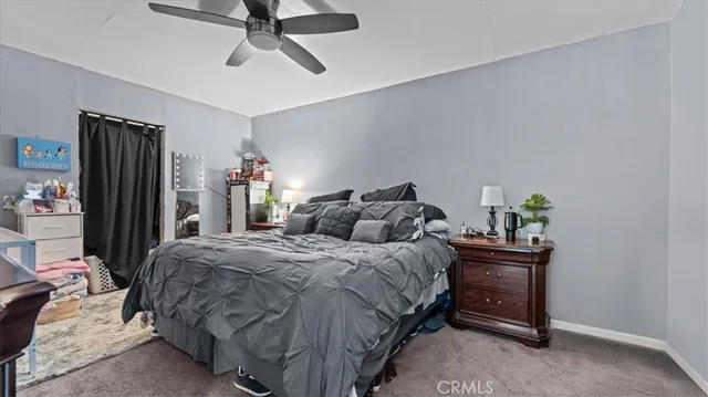a bedroom with a bed a dresser and a chandelier