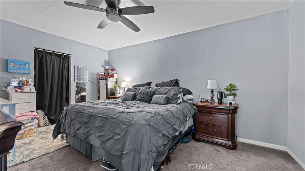 1030 North Western Avenue Colton, CA 92324 - Photo 14 of 32 a bedroom with a bed a dresser and a chandelier