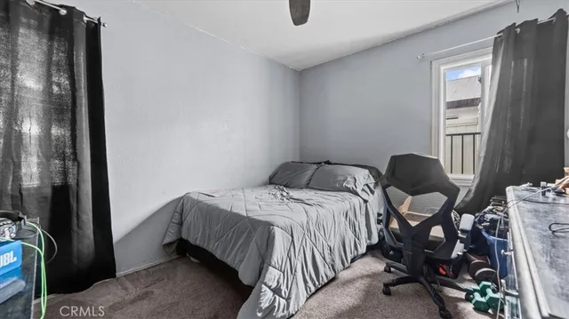 a bedroom with a bed and a cabinets next to a window