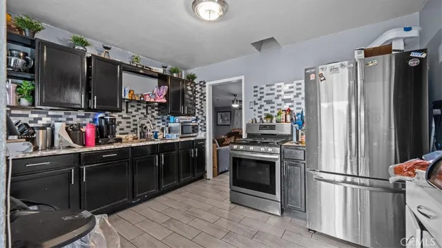 a kitchen with granite countertop a refrigerator and a sink