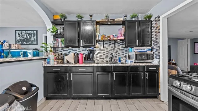 a kitchen with stainless steel appliances kitchen island granite countertop a refrigerator and a stove top oven