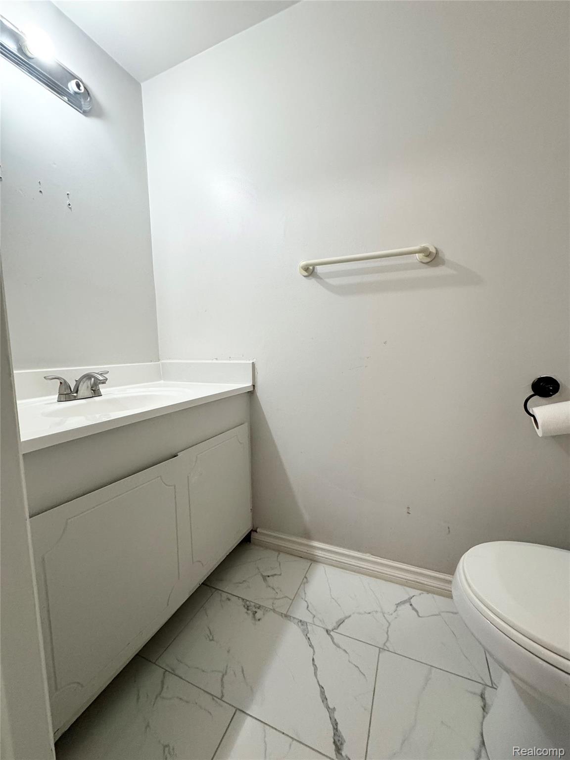 4386 15 Mile Road, Unit 64 Sterling Heights, MI 48310 - Photo 12 of 23 White vanity with an integrated sink and chrome faucet, set against white walls