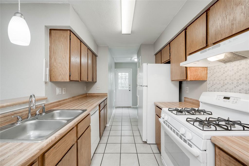 5503 Spring Meadow Road, Unit A Austin, TX 78744 - Photo 1 of 9 a kitchen with a sink stove and refrigerator