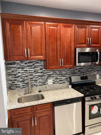 a kitchen with stainless steel appliances wooden cabinets and a sink