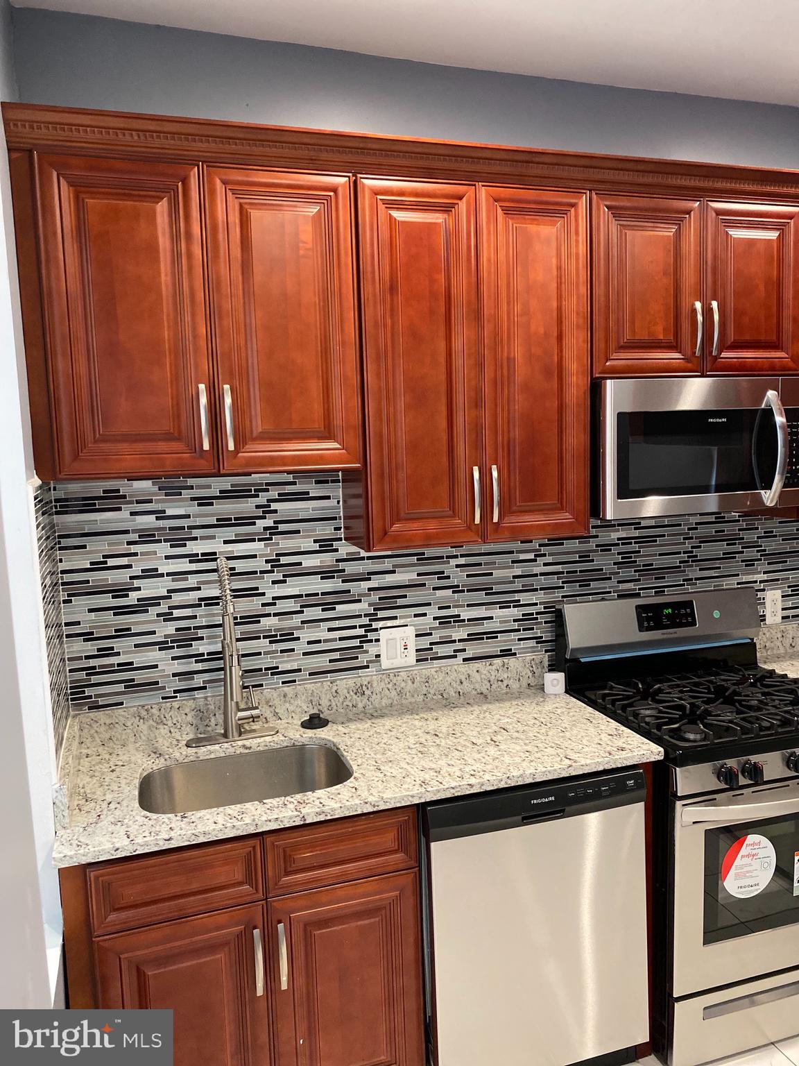 2658 Edmondson Avenue Baltimore, MD 21223 - Photo 2 of 27 a kitchen with stainless steel appliances wooden cabinets and a sink
