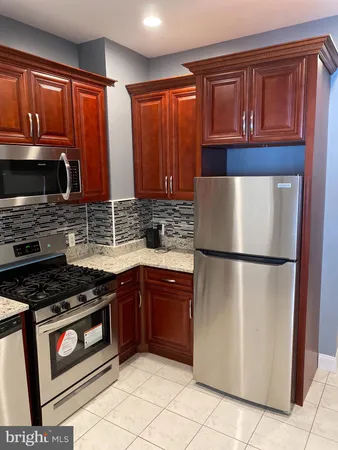 a kitchen with granite countertop a refrigerator stove top oven a sink and dishwasher