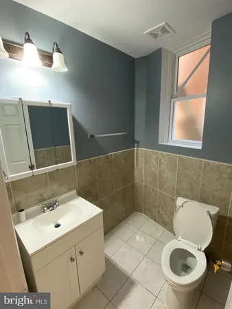 a bathroom with a toilet sink and mirror