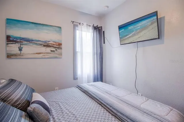 a bedroom with a bed and a painting on the wall
