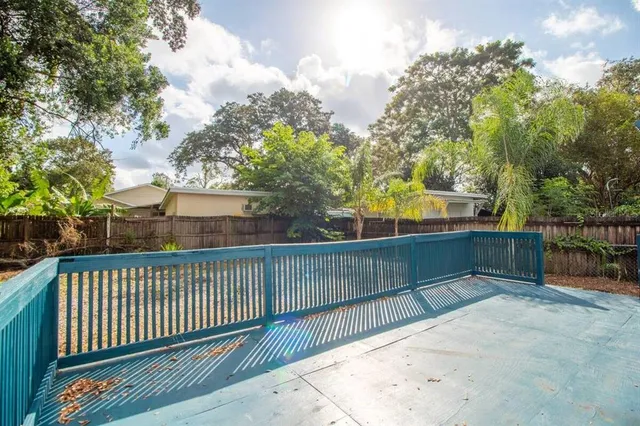 a view of backyard of house with wooden fence