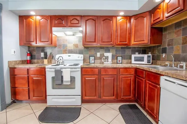 a kitchen with stainless steel appliances granite countertop wooden cabinets a sink and dishwasher
