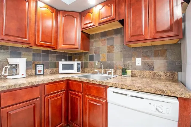 a kitchen with granite countertop stainless steel appliances stove microwave and cabinets