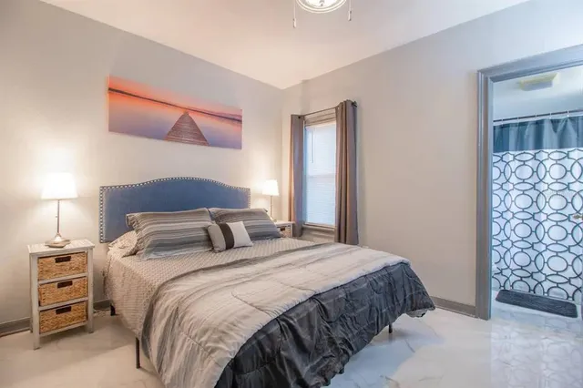 a bedroom with a bed and a lamp with the dresser